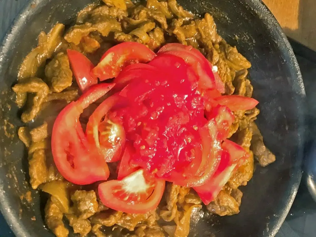 Adding tomatoes to lamb bhuna