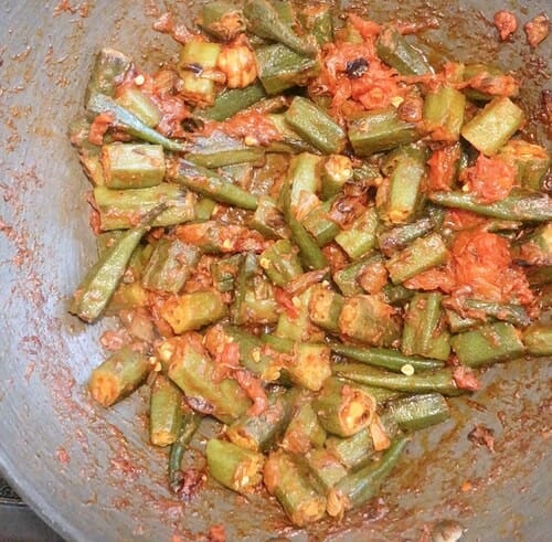Cook okra curry until tomatoes become pulpy