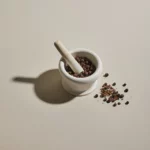 all spice berries in a mortar and pestle
