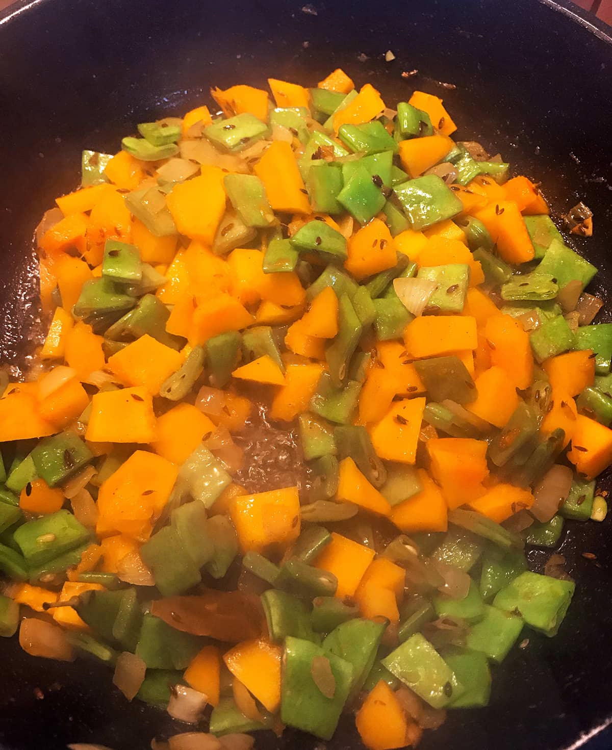 Cook red pumpkin and beans with the spices for Indian pumpkin curry