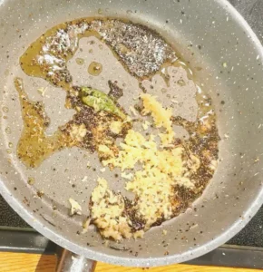 Frying pan with spices and grated ginger 