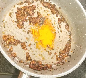 Whole spices, ginger and turmeric frying in a pan 