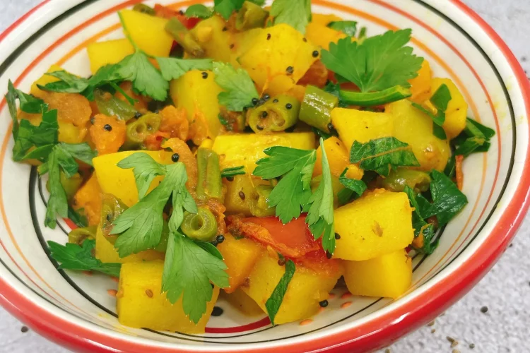 Indian Style pumpkin recipe, kaddu ki sabji in a red rimmed bowl